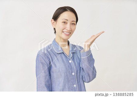 パジャマを着た女性　手のひらで右を指す　白バック 138885285