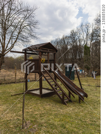 Children playing and having fun at a wooden playground in a park Children playing and having fun at a wooden playground in a park 138885810