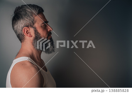 Man with gray beard looking to the side against a plain background Man with gray beard looking to the side against a plain background 138885828