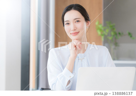 綺麗なオフィスで正面のカメラ目線でポジティブに考えるポーズの前向きに働く女性のキャリア 138886137