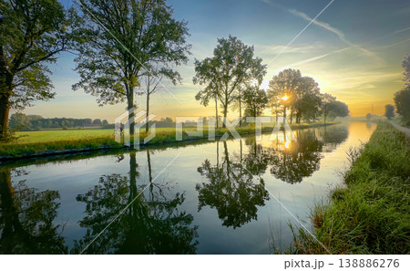 A colorful sunrise reflection over a tranquil canal captivates viewers with beauty and harmony 138886276