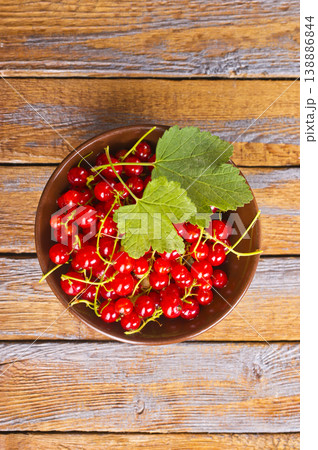 Red currant berries, fresh ripe and raw redcurrants in a wooden bowl on a table 138886844