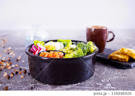 Salmon bowl with spinach, rice, avocado, tomato, cucumbers on a white background, top view. Salmon bowl with spinach, rice, avocado, tomato, cucumbers on a white background, top view. 138886926