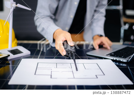 Engineer using tablet near solar panel and wind turbine model, representing clean energy, green innovation, and smart technology Engineer using tablet near solar panel and wind turbine model, representing clean energy, green innovation, and smart technology 138887472