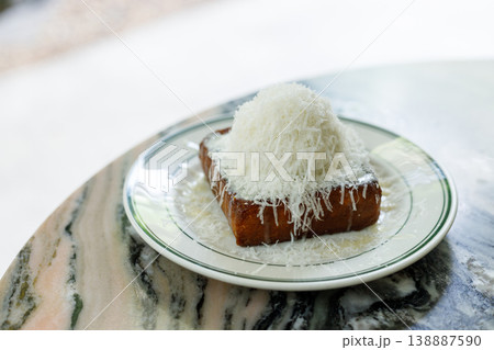 Fresh bread butter toast with Vanilla flavor ice cream topped with grated Parmesan cheese on white ceramic plate on marble table. Fresh bread butter toast with Vanilla flavor ice cream topped with grated Parmesan cheese on white ceramic plate on marble table. 138887590