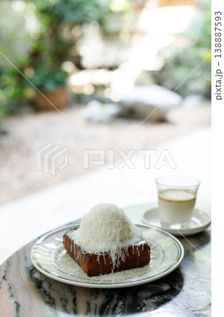 Fresh bread butter toast with Vanilla flavor ice cream topped with grated Parmesan cheese on white ceramic plate on marble table. 138887593