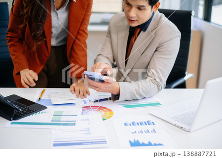 Two professionals working together using tablet and printed reports in a modern office. Perfect for teamwork, strategy, financial planning Two professionals working together using tablet and printed reports in a modern office. Perfect for teamwork, strategy, financial planning 138887721