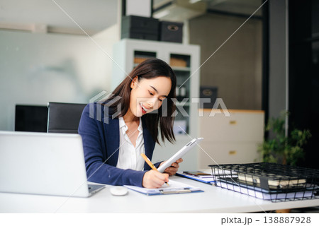 businesswoman working with working notepad, tablet and laptop documents talking on the smartphone, tablet and laptop 138887928