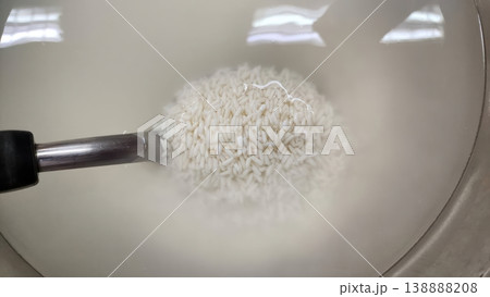 Washing Raw White Rice in a Stainless Steel Bowl for Cooking Preparation Washing Raw White Rice in a Stainless Steel Bowl for Cooking Preparation 138888208