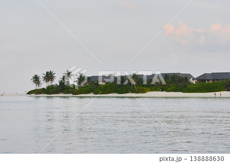 Classic Maldives island landscape on a sunset, azure water, white sand, palm trees on the shore Classic Maldives island landscape on a sunset, azure water, white sand, palm trees on the shore 138888630