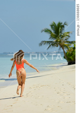 A beautiful tanned girl with an athletic physique in a swimsuit runs on the personal beach of the villa on a sunny day in the Maldives, she is happy and posing A beautiful tanned girl with an athletic physique in a swimsuit runs on the personal beach of the villa on a sunny day in the Maldives, she is happy and posing 138888685