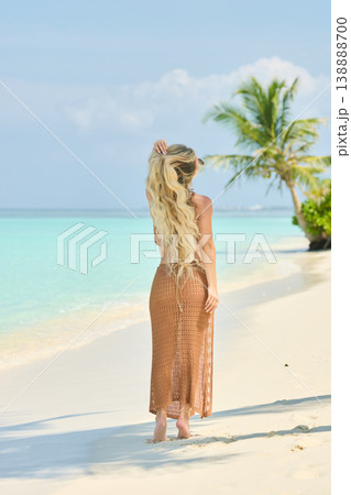 A beautiful tanned girl with an athletic physique in a swimsuit runs on the personal beach of the villa on a sunny day in the Maldives, she is happy and posing A beautiful tanned girl with an athletic physique in a swimsuit runs on the personal beach of the villa on a sunny day in the Maldives, she is happy and posing 138888700