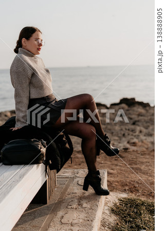 Woman Ocean Bench sitting at the seaside in autumn attire looking at the horizon during sunset copy space Woman Ocean Bench sitting at the seaside in autumn attire looking at the horizon during sunset copy space 138888905