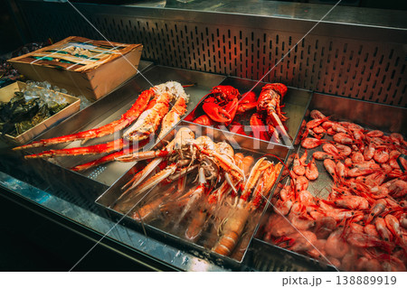 Trade in seafood seafood in the local Market. Close-up of a gourmet seafood display with lobsters, crabs, and fresh fish on ice at indoor market hall. Close-up of a gourmet seafood display with 138889919