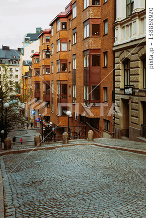 Red brick residential buildings on hilly cobblestone street in Sodermalm, Stockholm 138889920