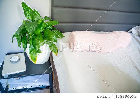 Ergonomic orthopedic pillow on bed in modern bedroom interior. Cervical support pillow for proper neck alignment, posture correction and comfortable healthy sleep at home 138890053