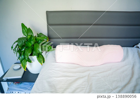 Ergonomic orthopedic pillow on bed in modern bedroom interior. Cervical support pillow for proper neck alignment, posture correction and comfortable healthy sleep at home 138890056