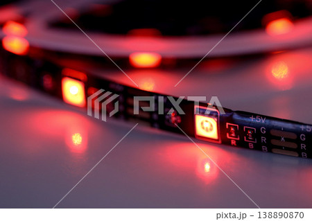 Red LED strip light glowing with electronic circuit detail on white background 138890870