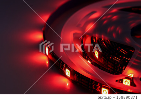Red LED strip light close-up with glowing illumination on dark background Red LED strip light close-up with glowing illumination on dark background 138890871