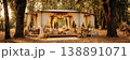 A wedding tent is set up in a grassy space with trees around. Inside, there are cushions and lights creating a cozy atmosphere for guests to relax and enjoy 138891071