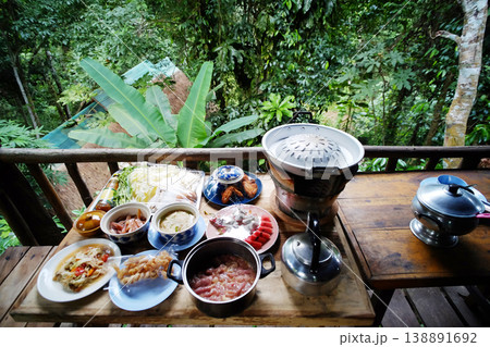 Top view of Moo Krata set, Thai food and Barbecue set on wooden table on terrace and tropical forest in Thailand 138891692