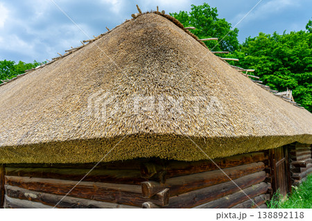 A typical Ukrainian ancient house covered with straw stands quietly, reflecting traditional rural architecture and cultural heritage in Ukraine. 138892118