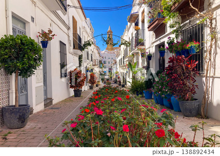 A bright white street lined with colorful flower pots and blooming plants creates a charming Mediterranean scene in Estepona, Spain A bright white street lined with colorful flower pots and blooming plants creates a charming Mediterranean scene in Estepona, Spain 138892434