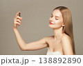 Beautiful woman spraying thermal water on her face 138892890