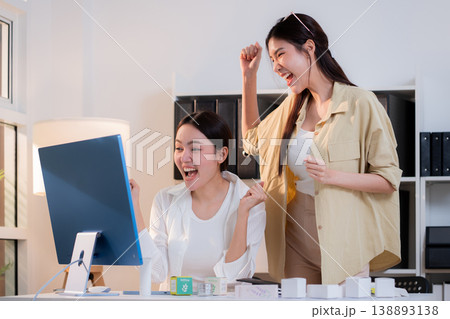 Two asian businesswoman team celebrate success with excited for cosmetic packaging design. Two asian businesswoman team celebrate success with excited for cosmetic packaging design. 138893138