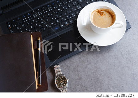 淹れたての美味しいコーヒーを飲みながら、ノートパソコンとシステム手帳でデスクワークをしているイメージ 淹れたての美味しいコーヒーを飲みながら、ノートパソコンとシステム手帳でデスクワークをしているイメージ 138893227