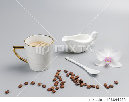 Cup of coffee, a spoon and a cream sauceboat. Cup of coffee, a spoon and a cream sauceboat. 138894953