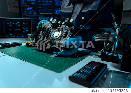 Computer Hardware Technician Repairing Motherboard with Soldering Iron in Electronics Lab. 138895298