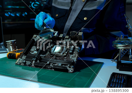 Computer Hardware Technician Repairing Motherboard with Soldering Iron in Electronics Lab. 138895300
