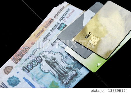 Russian rubles and plastic bank cards on a black background Russian rubles and plastic bank cards on a black background 138896134