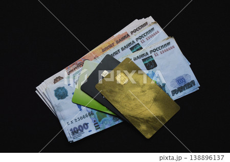 Russian rubles and plastic bank cards on a black background Russian rubles and plastic bank cards on a black background 138896137