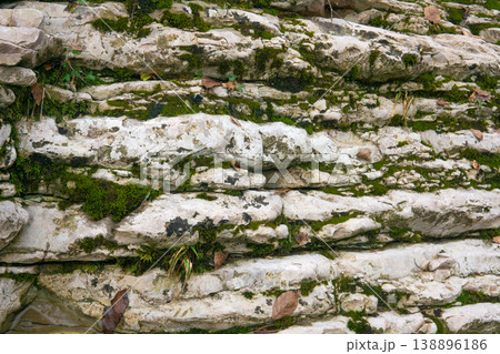 Stone wall with moss and lichen. Natural stone background texture. 138896186