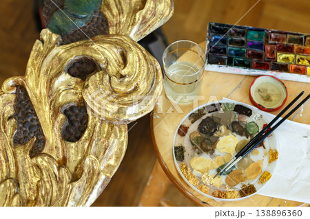 Artist Prepares Paint and Tools on Wooden Table in Studio While Creating Art Project in Afternoon Light 138896360