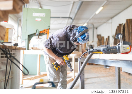 Carpenter working wood in workshop using power tools Carpenter working wood in workshop using power tools 138897831