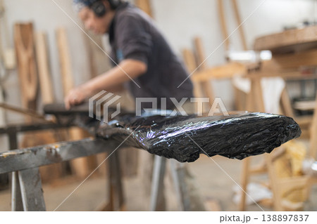 Artisan applying finish coating to live edge wood slab Artisan applying finish coating to live edge wood slab 138897837