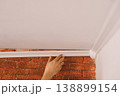 Installing crown molding in room corner, interior renovation and finishing work 138899154