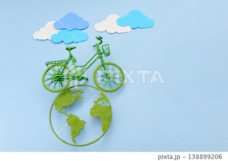 World bicycle day. Green bicycle riding a clean energy path on planet earth World bicycle day. Green bicycle riding a clean energy path on planet earth 138899206