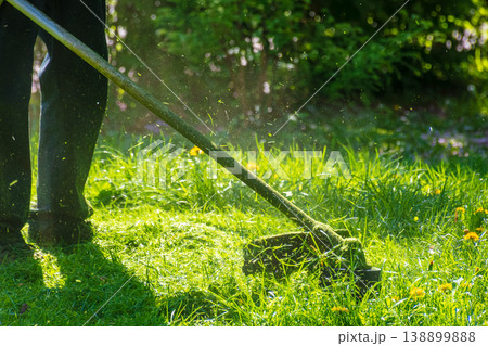 professional garden service at work. lawn care concept. cutting an mowing grass in the park. spring summer season. backlit gardening scene. grass ground view for design 138899888