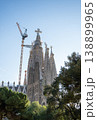 Sagrada Familia towers with construction crane and trees under blue sky in Barcelona Spain 138899965