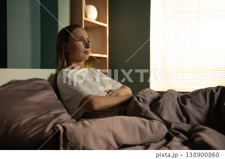 Woman lying awake in bed at night, feeling frustrated and stressed due to a sleep disorder or difficulty falling asleep, indicating an issue with rest and a disturbed circadian rhythm Woman lying awake in bed at night, feeling frustrated and stressed due to a sleep disorder or difficulty falling asleep, indicating an issue with rest and a disturbed circadian rhythm 138900860