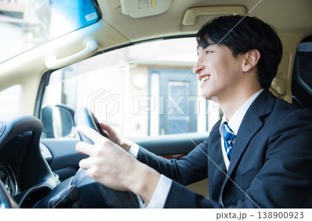 運転中にスマートフォンを見る若いビジネスマン 138900923