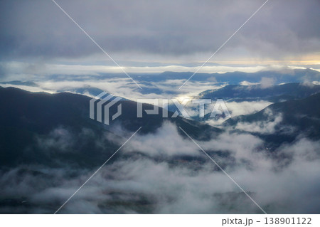 北海道・夜明けの濃い雲海に覆われた山間の谷。山々の間に雲海が広がる幻想的な朝の情景。山間に広がる幻想 北海道・夜明けの濃い雲海に覆われた山間の谷。山々の間に雲海が広がる幻想的な朝の情景。山間に広がる幻想 138901122