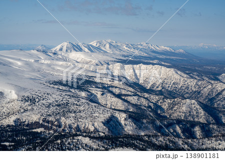 北海道冬・高所から望む雪山連峰の絶景。北海道の大自然を代表する絶景。白銀に輝く山頂と澄み渡る青空の冬 北海道冬・高所から望む雪山連峰の絶景。北海道の大自然を代表する絶景。白銀に輝く山頂と澄み渡る青空の冬 138901181