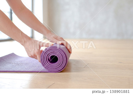 ヨガマットを巻く手元のクローズアップ 138901881