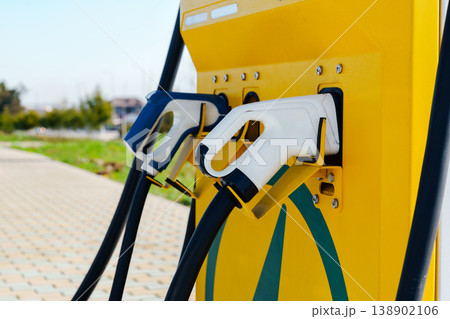 Electric car charger setup at public station for convenient charging in urban area Electric car charger setup at public station for convenient charging in urban area 138902106