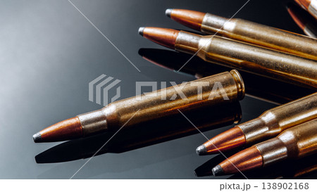 Close view of a group of metal bullets on a black surface at a shooting range Close view of a group of metal bullets on a black surface at a shooting range 138902168